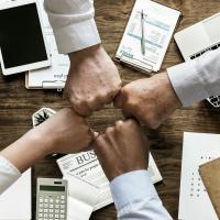 Foto de punhos fechados concêntricos sobre mesa de trabalho.