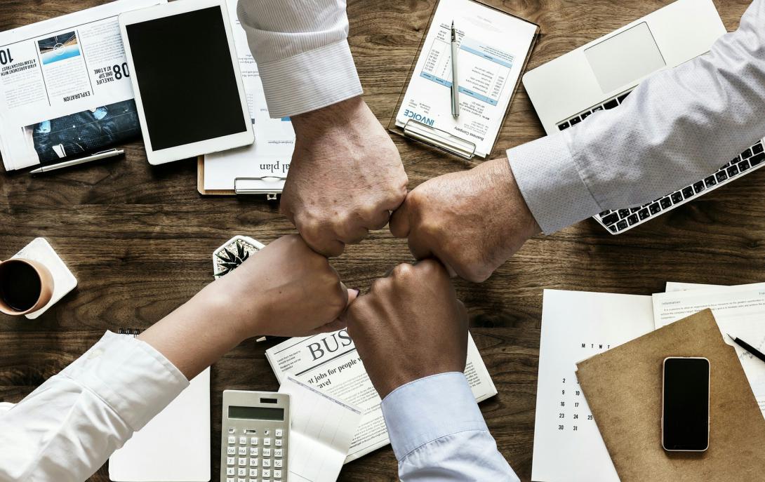 Foto de punhos fechados concêntricos sobre mesa de trabalho.