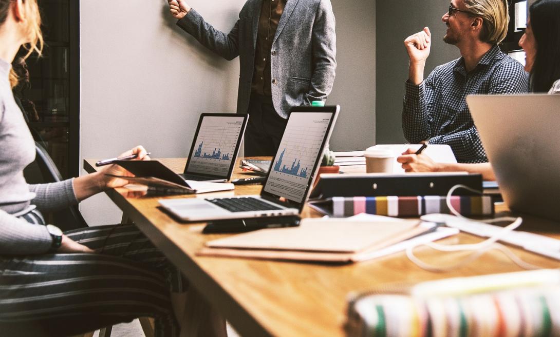 Reunião com a participação de 04 pessoas, que utilizam computadores e cadernetas.